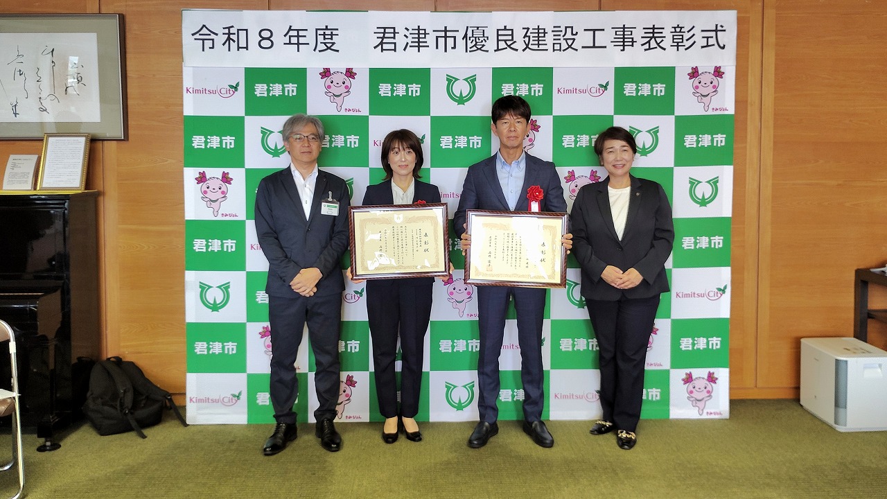 記念撮影に応じる出席者（左から石川部長、川上氏、伊藤代表取締役、石井市長）